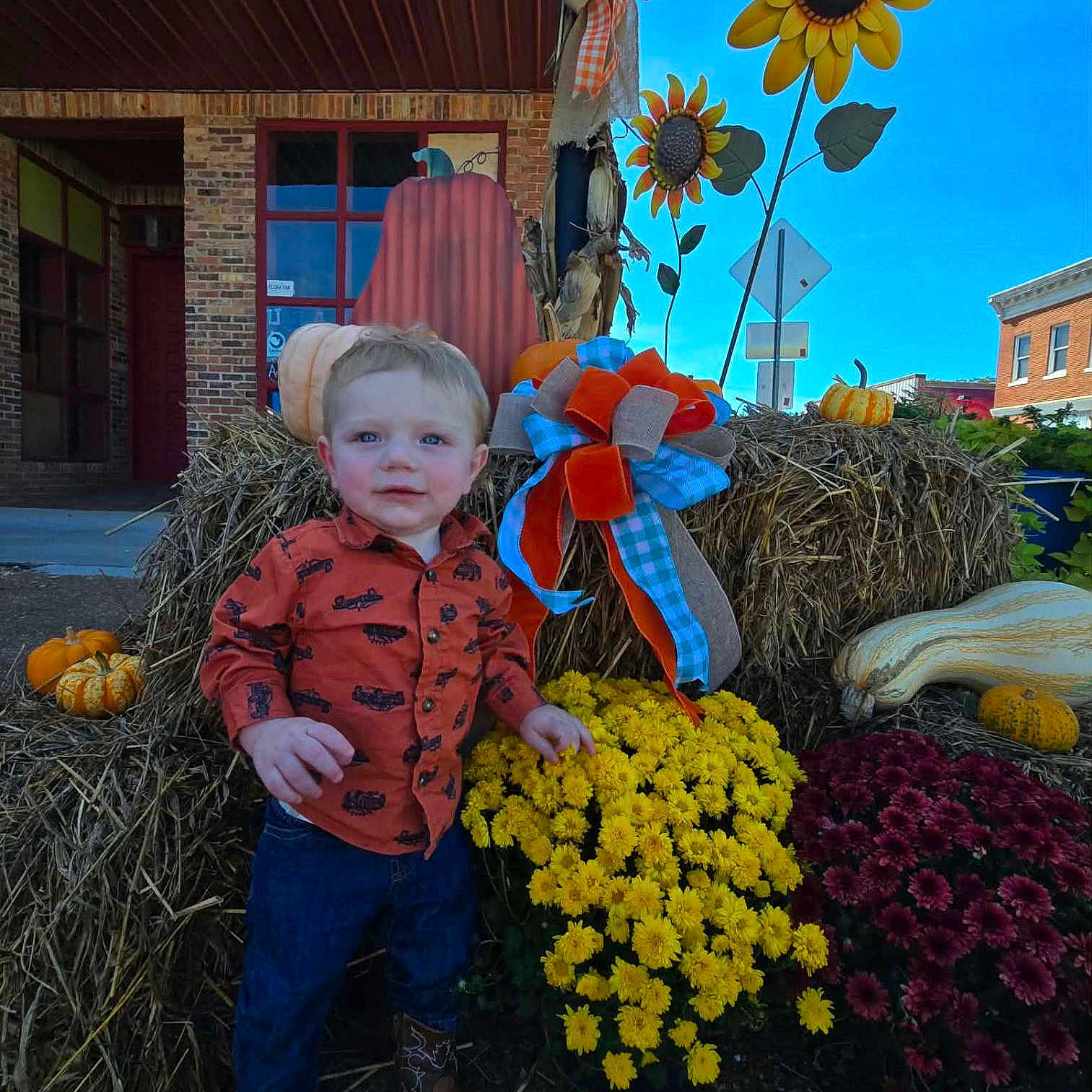 Oliver joined the competition — help win amazing prizes! child, toddler, portrait, outdoor, autumn, fall, pumpkin, gourd, sunflower, hay_bale, flowers, mums, garden, farm, decorations, blue_sky, brick_building, red_shirt, jeans, boots