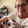 Zoey is registered to the contest to win money with this photo: casual, closeup, cute, decor, dog, expression, face, flowers, furniture, glasses, headband, home, indoor, mature, person, pet, portrait, shelf, small_dog, white_shirt