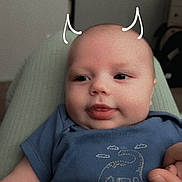 Jaxon joined the competition — help win amazing prizes! baby, infant, blue_shirt, dinosaur_print, doodle, devil_horns, hand, person, cute, lying_down, indoors, child, face, skin, expression, clothing, pacifier_clip, soft_light, portrait, smile