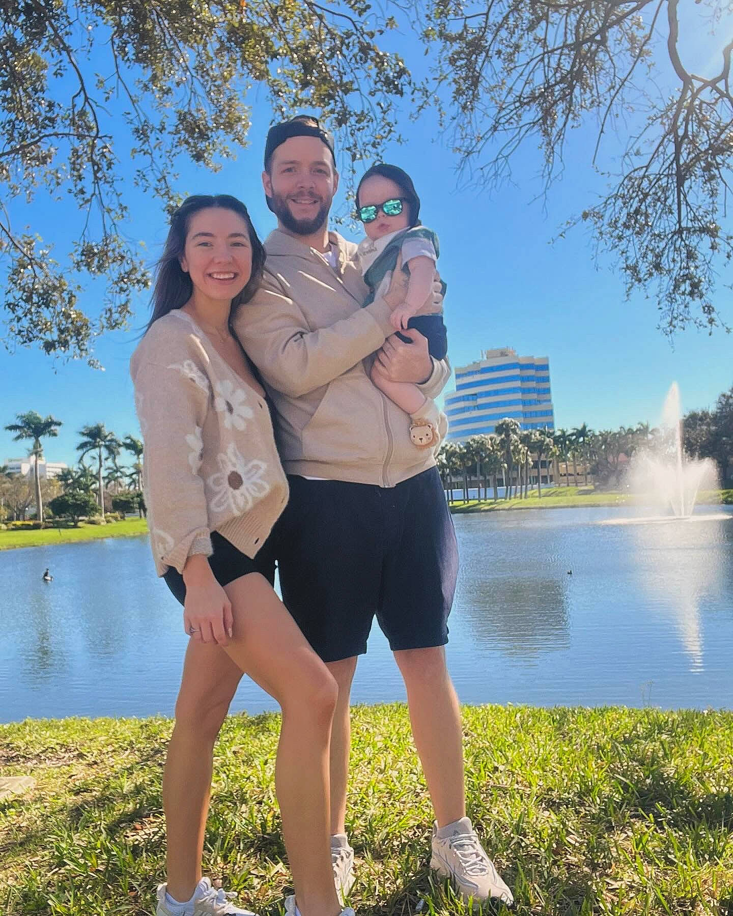 Jaxon is registered to the contest to win money with this photo: bank, daytime, friendship, fun, gesture, grass, happy, headwear, interaction, joy, lake, leg, leisure, people_in_nature, person, plant, shorts, sky, smile, standing