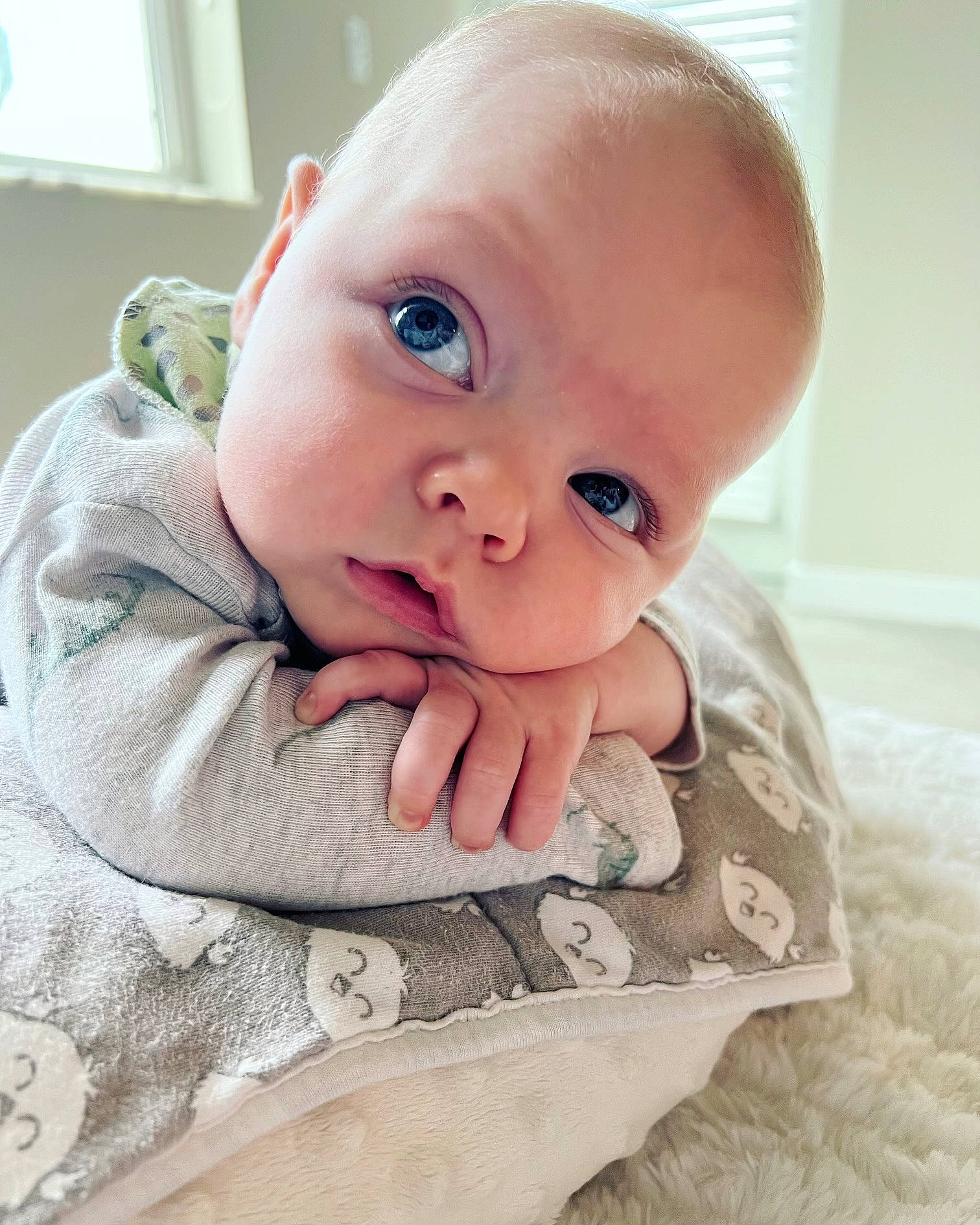 Jaxon is registered to the contest to win money with this photo: baby, baby_toddler_clothing, cheek, child, comfort, eyelash, flooring, gesture, hand, happy, linens, lip, nail, nose, person, product, skin, sleeve, thumb, toddler