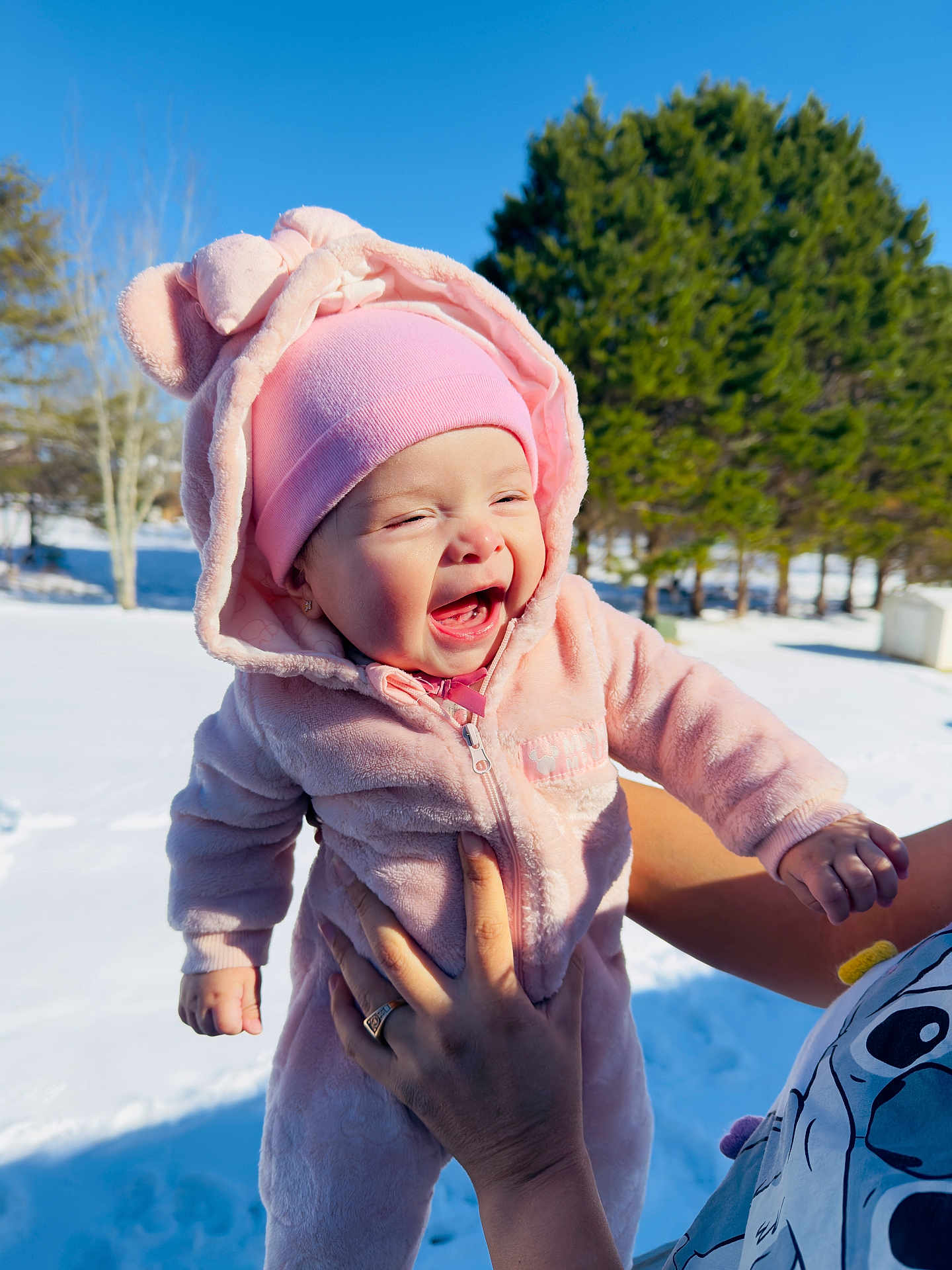 Lauren joined the competition — help win amazing prizes! baby, child, pink_clothing, hat, hood, outdoor, snow, winter, tree, smiling, happy, person, hand, sunlight, forest, nature, cute, cold, joyful, playful