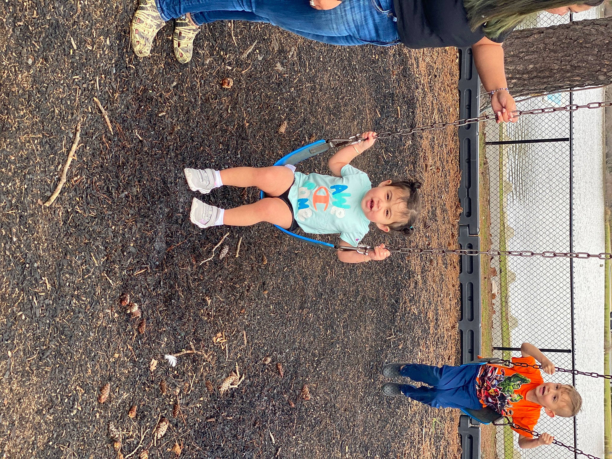 Katherine is registered to the contest to win money with this photo: asphalt, blue, city, clothing, electric_blue, fence, fun, grass, human_leg, knee, leisure, mesh, people_in_nature, person, recreation, road_surface, shorts, soil, thigh, toddler