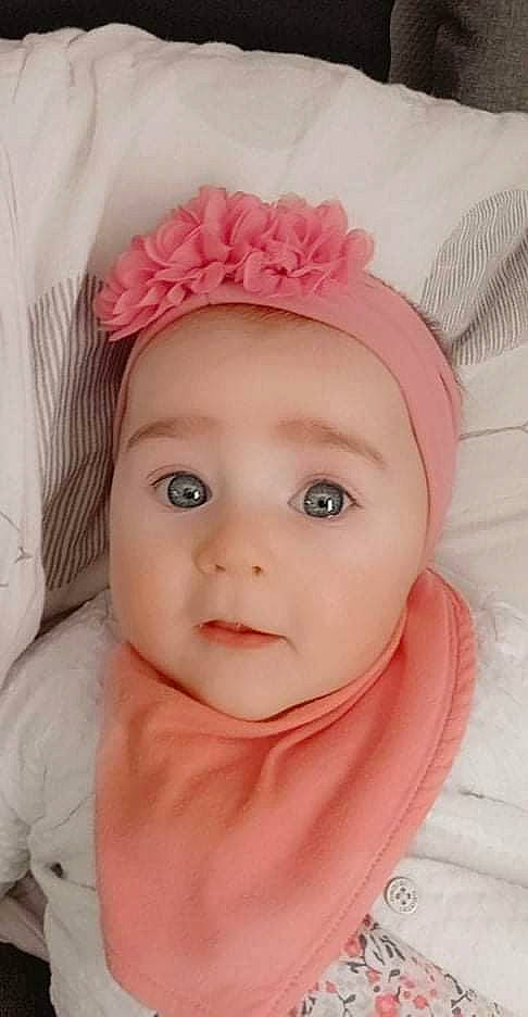 Emy participe au concours pour gagner de l'argent avec cette photo : baby, baby_toddler_clothing, cap, cheek, child, chin, eyebrow, eyelash, fashion_accessory, hair_accessory, headband, headgear, headpiece, headwear, lip, magenta, person, pink, skin, sleeve