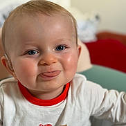 Raphaël a rejoint le concours — aidez-le/la à gagner de superbes lots ! baby, child, tongue_out, cute, smiling, white_shirt, red_collar, indoor, face, blue_eyes, skin, infant, person, portrait, young_child, playful, closeup, happy, expression, seated
