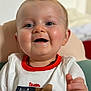 Raphaël a rejoint le concours — aidez-le/la à gagner de superbes lots ! baby, child, smiling, face, blue_eyes, white_shirt, red_trim, animal_graphic, happy, close_up, portrait, infant, cute, young_child, indoor, skin, hand, necklace, light, soft_background