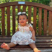 Violet joined the competition — help win amazing prizes! child, toddler, smiling, dress, white_dress, bow, headband, barefoot, bench, wooden_bench, outdoor, sunlight, greenery, happy, cute, portrait, baby, person, summer, nature