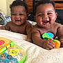 Aiden And Caden is registered to the contest to win money with this photo: baby, smiling, laughing, toy, bed, blanket, cute, infant, child, happy, indoors, playful, face, skin, hair, person, expression, joy, colorful, comfort