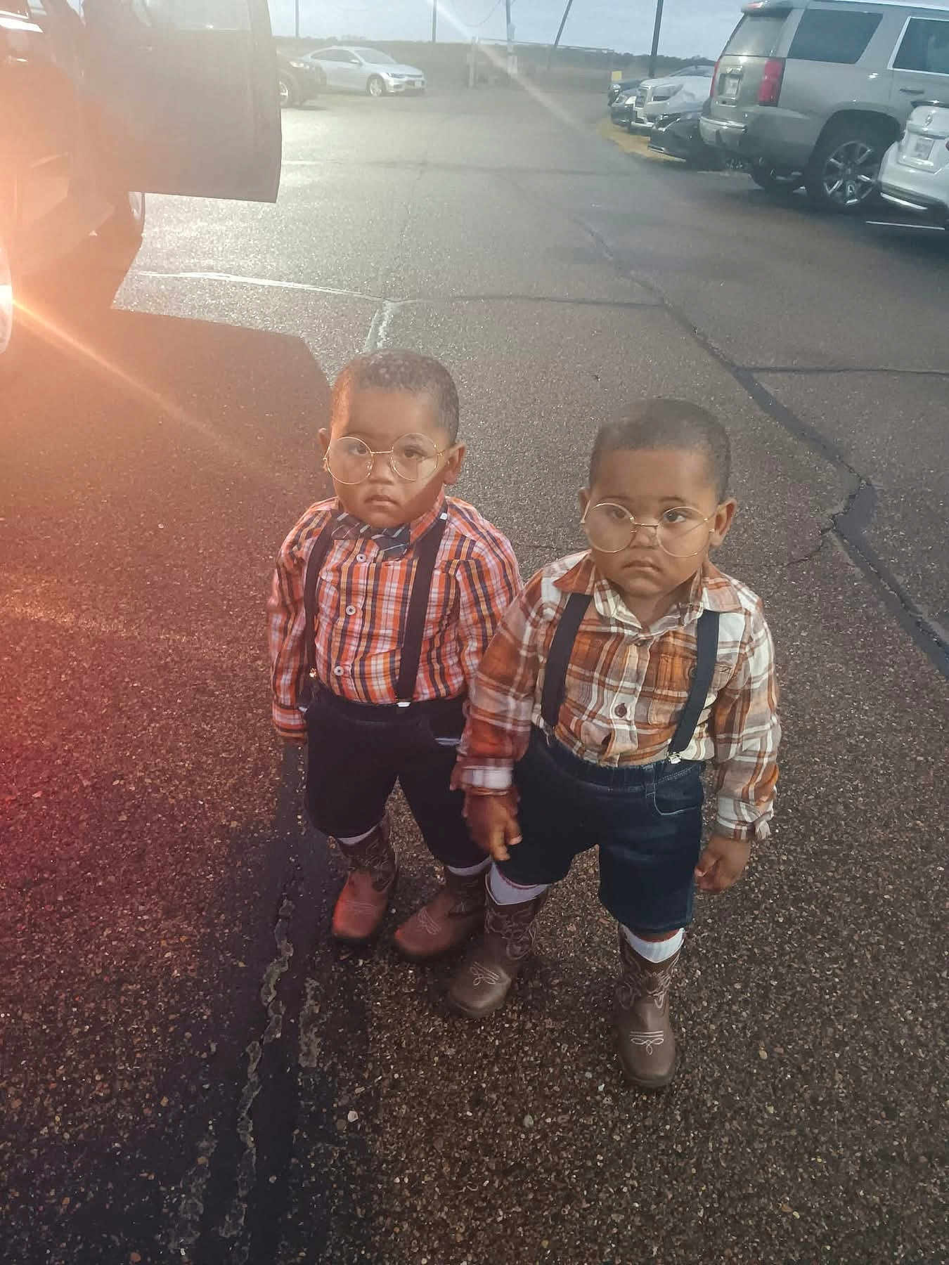 Aiden And Caden is registered to the contest to win money with this photo: toddler, child, glasses, plaid_shirt, suspenders, cowboy_boots, outdoor, parking_lot, asphalt, two_children, serious_expression, short_hair, daylight, vehicles, cars, boys, fashion, matching_outfits, standing, sunlight