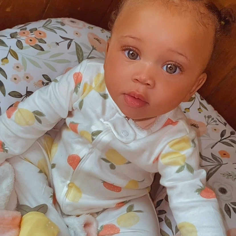 Sevyn is registered to the contest to win money with this photo: baby, blanket, clothing, crawling, face, hair, head, person, photography, portrait, quilt, sitting, sleeve, spitting