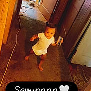 Sevyn is registered to the contest to win money with this photo: baby, blur, candid, carpet, child, clutter, door, doorway, floor, hallway, household, indoors, name_label, onesie, person, text_overlay, toddler, walking, warm_lighting, wood_paneling