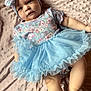 baby, infant, child, blue_tutu, headband, bow, floral_pattern, blanket, soft_texture, cute, portrait, lying_down, clothing, apparel, skin, face, legs, expression, indoors, person