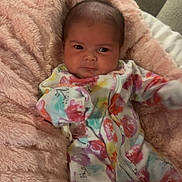 Raven is registered to the contest to win money with this photo: baby, infant, blanket, fluffy, colorful_clothing, onesie, face, couch, indoor, soft_texture, child, cute, portrait, newborn, comfort, resting, small_person, warm, expression, seated