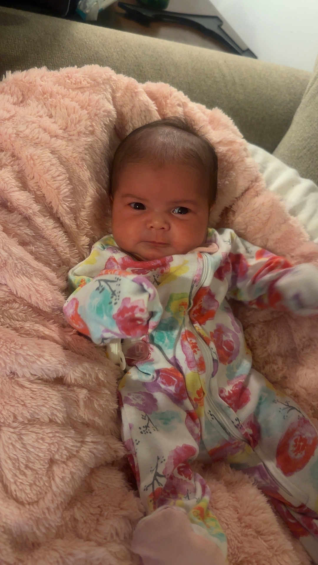 Raven is registered to the contest to win money with this photo: baby, infant, blanket, fluffy, colorful_clothing, onesie, face, couch, indoor, soft_texture, child, cute, portrait, newborn, comfort, resting, small_person, warm, expression, seated
