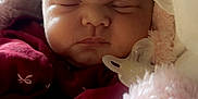 Raven is registered to the contest to win money with this photo: baby, sleeping, pacifier, blanket, maroon_clothing, infant, soft_texture, cozy, face, peaceful, newborn, wrapped, cute, child, portrait, closeup, indoors, tender, resting, adorable