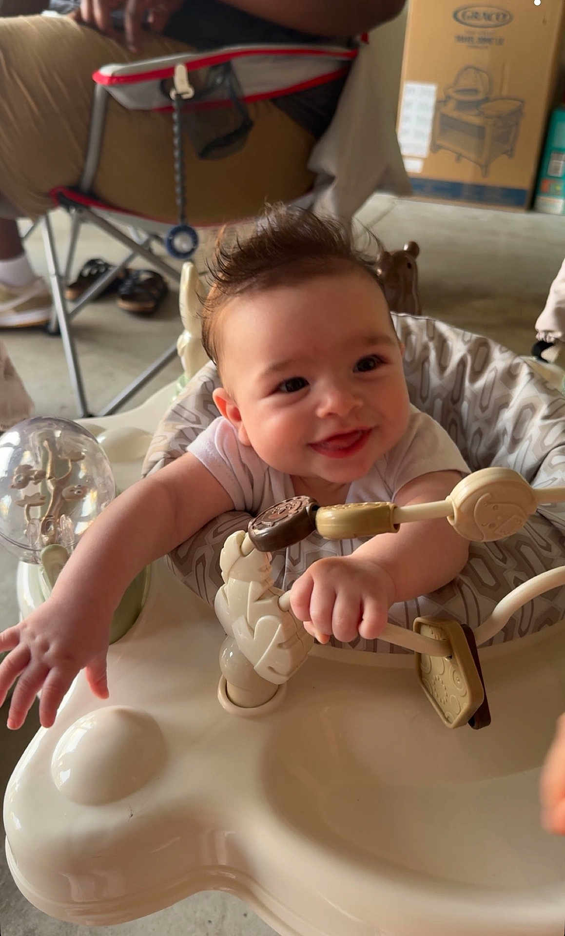 Eastyn joined the competition — help win amazing prizes! baby, smiling, infant, activity_center, toy, indoor, person, child, happy, reaching, seat, furniture, adult, legs, clothing, floor, hand, face, expression, hair