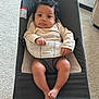 baby, infant, bouncer, babybjorn, curly_hair, indoor, carpet, clothing, person, face, legs, feet, hand, expression, child, cute, relaxing, seat, furniture, home