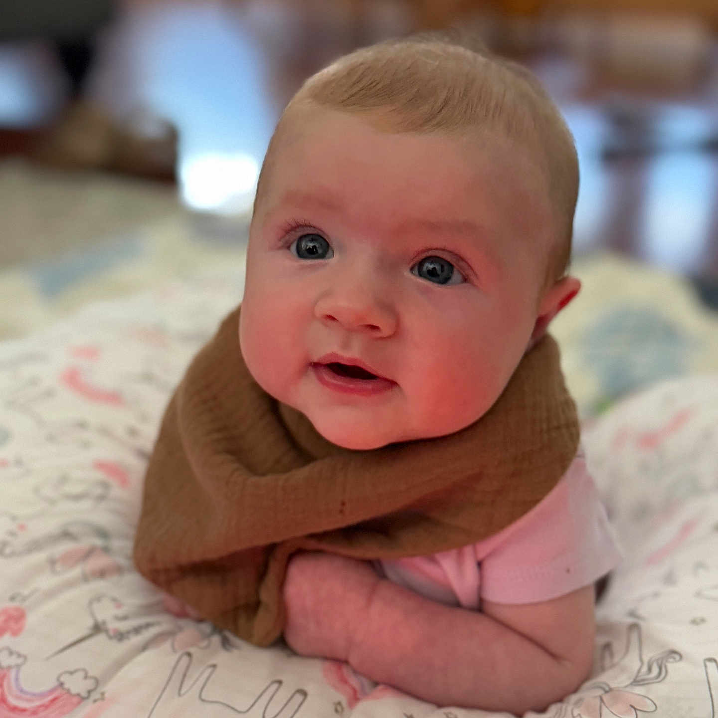 Leylanie is registered to the contest to win money with this photo: baby, brown_bib, cheeks, child, curious_expression, cute, eyes, face, indoors, infant, laying_down, person, pillow, pink_clothing, portrait, skin, soft_focus, toddler, unicorn_pattern, young