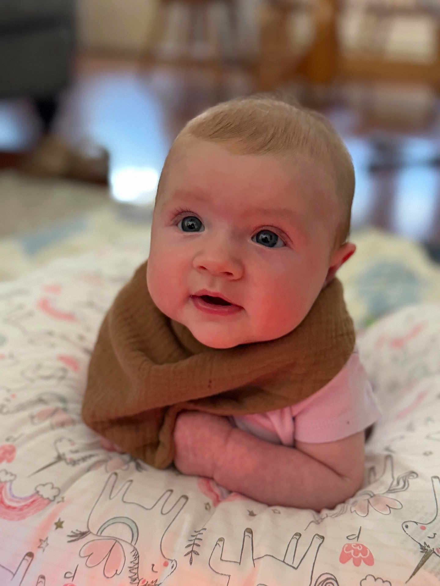 Leylanie is registered to the contest to win money with this photo: baby, brown_bib, cheeks, child, curious_expression, cute, eyes, face, indoors, infant, laying_down, person, pillow, pink_clothing, portrait, skin, soft_focus, toddler, unicorn_pattern, young