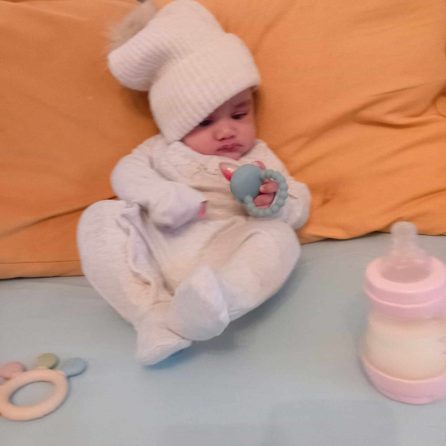 Muhammad Zaain is registered to the contest to win money with this photo: baby, bed, bottle, child, cozy, cute, hat, indoors, infant, nursery, person, pillow, resting, sitting, soft_toys, teething_ring, toy, warm, white_clothing, yellow_pillow