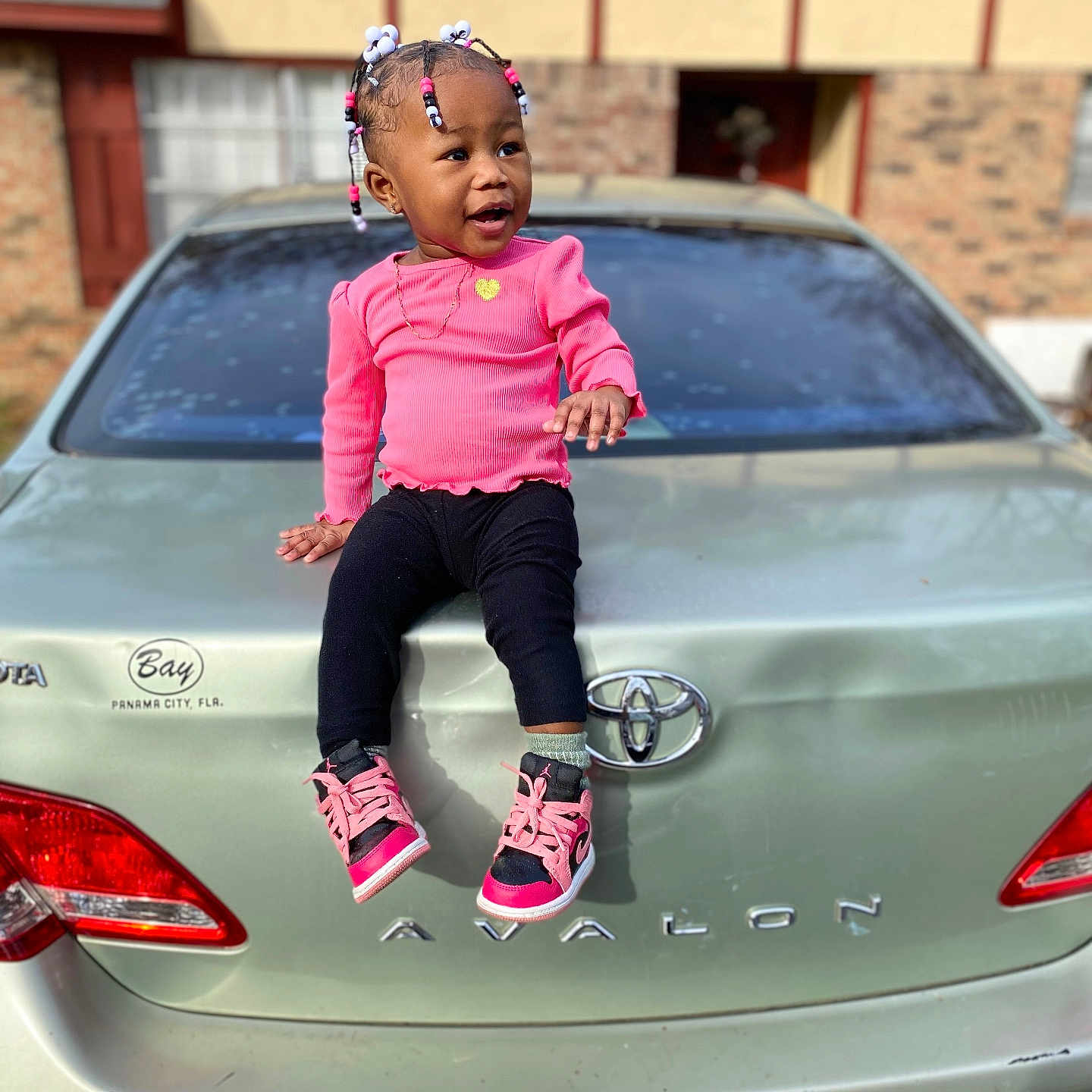 Aalaiyah is registered to the contest to win money with this photo: bumper, car, child, clothing, face, female, footwear, girl, head, licenseplate, pants, person, photography, portrait, shoe, sitting, sleeve, sneaker, transportation, vehicle