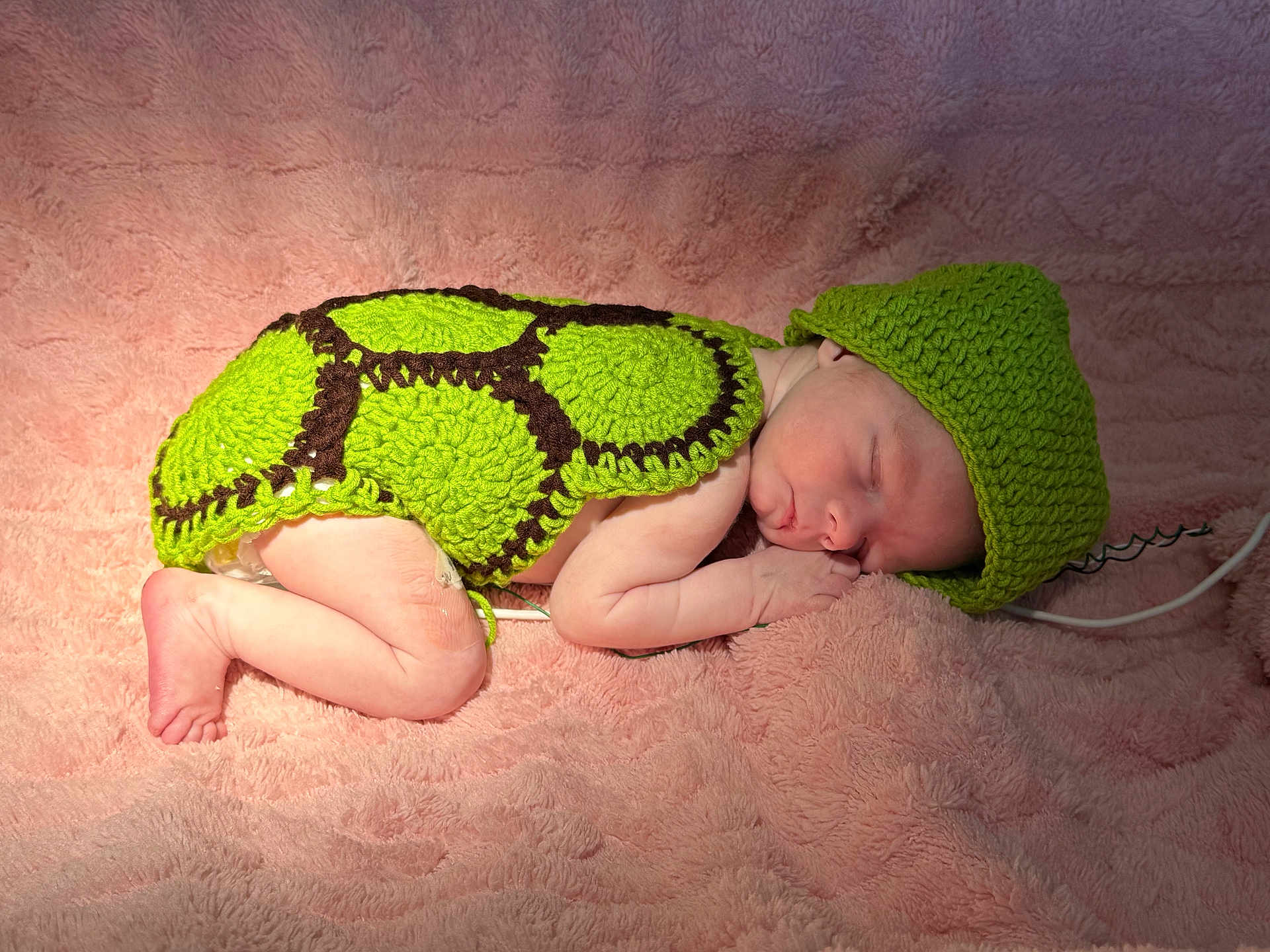 Selah is registered to the contest to win money with this photo: newborn, baby, sleeping, crocheted_clothing, green, turtle_costume, pink_blanket, soft_texture, infant, cute, peaceful, headwear, wrapped, lying_down, indoors, portrait, skin, small_hands, small_feet, resting