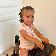 Elena a rejoint le concours — aidez-le/la à gagner de superbes lots ! toddler, child, indoor, rocking_horse, wooden_toy, braided_hair, pink_clothing, floor, door, play, young_child, curious_expression, toy, furniture, childhood, person, portrait, hands, smile, happy