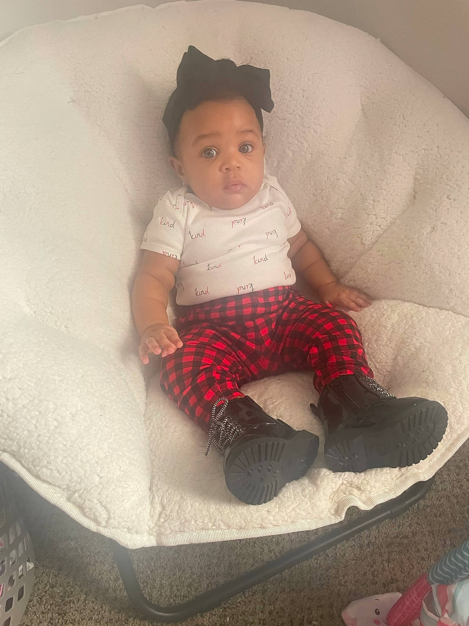 Emery is registered to the contest to win money with this photo: arm, baby, baby_products, baby_toddler_clothing, cap, carmine, child, comfort, doll, human_leg, linens, pattern, person, room, sitting, sleeve, sock, t_shirt, throw_pillow, toddler