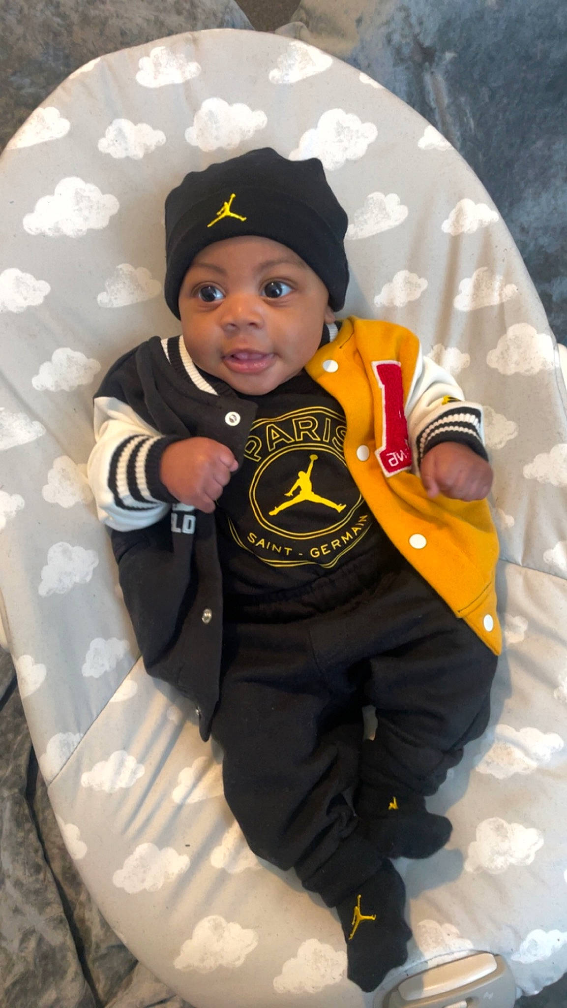 Isiah joined the competition — help win amazing prizes! baby, baby_toddler_clothing, baseball_cap, beanie, cap, carmine, child, fun, gesture, glove, hat, headgear, headwear, hoodie, logo, outerwear, person, personal_protective_equipment, sitting, sleeve
