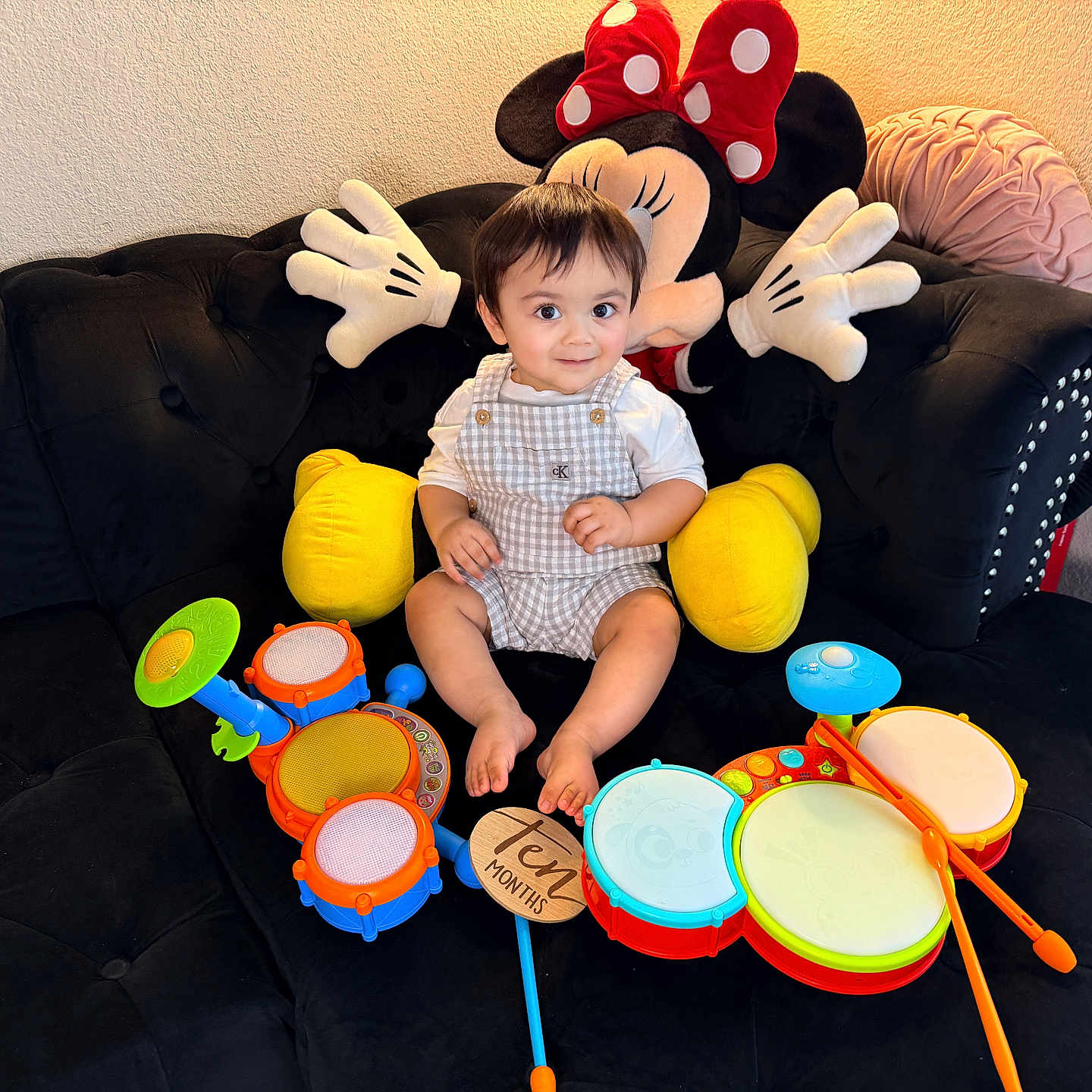 Zohan joined the competition — help win amazing prizes! baby, child, toy, drum, plush, minnie_mouse, couch, black_couch, smile, indoor, happy, childrens_toy, colorful, playtime, cute, sitting, person, living_room, soft_toy, infant