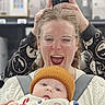 Westley joined the competition — help win amazing prizes! woman, baby, glasses, knit_hat, mirror, selfie, smile, winking, hand, playful, clothing, indoor, person, face, holding, joyful, cute, baby_carrier, white_sweater, background