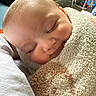 baby, sleeping, towel, blanket, closeup, face, infant, cozy, peaceful, rosy_cheeks, indoor, soft_texture, head, person, wrapped, resting, child, human, portrait, warm