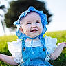 Josie is registered to the contest to win money with this photo: baby, child, infant, smiling, happy, portrait, outdoor, meadow, grass, blue_bonnet, denim_overalls, white_shirt, sunlight, nature, greenery, blurred_background, blue_eyes, sitting, arms_raised, photography