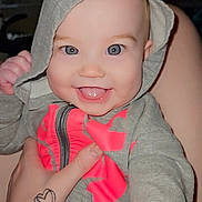 Aviana is registered to the contest to win money with this photo: baby, hoodie, smiling, tongue, hand, tattoo, indoor, clothing, person, face, child, cute, happy, gray, pink, zipper, skin, portrait, young, warm