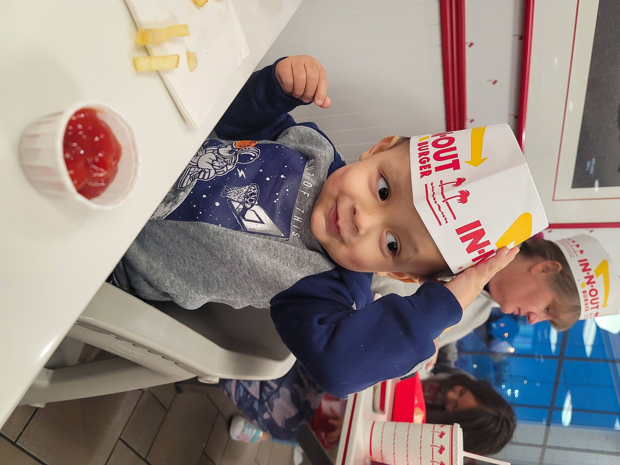 Luciano is registered to the contest to win money with this photo: baby, baby_products, baby_toddler_clothing, child, condiment, event, happy, hat, headwear, joy, ketchup, person, plate, red, room, tableware, toddler, under_exposed