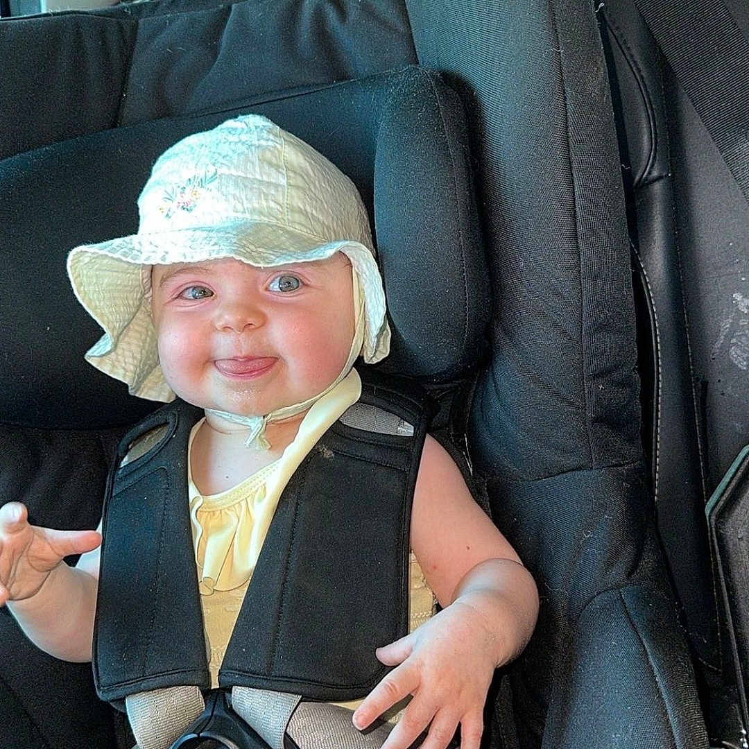 Giulia a rejoint le concours — aidez-le/la à gagner de superbes lots ! baby, car, car_interior, car_seat, child, clothing, cute, happy, hat, infant, person, portrait, safety, seat, seatbelt, smiling, sunhat, tongue_out, travel, young_child
