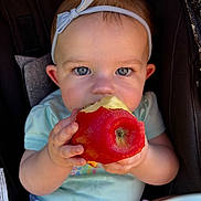 Kynslee joined the competition — help win amazing prizes! apple, baby, blue, chewing, child, closeup, clothing, cute, eyes, face, food, fruit, hand, headband, infant, natural_light, portrait, seat, skin, stroller