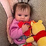 Kenna joined the competition — help win amazing prizes! baby, child, pigtails, pink_sweater, toy, stuffed_animal, winnie_the_pooh, couch, blanket, indoors, cute, infant, soft_texture, seated, holding, playful, young_child, portrait, cozy, casual