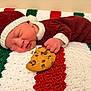 newborn, baby, sleeping, cookie, knit_hat, knit_suit, blanket, crochet, red, green, white, chocolate_chip_cookie, hand, face, infant, cute, resting, indoors, holiday, cozy
