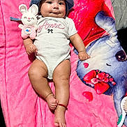 Isabella is registered to the contest to win money with this photo: baby, infant, blue_hat, onesie, plush_toy, pink_blanket, smiling, cute, child, lying_down, soft_toy, face, happy, indoors, closeup, adorable, legs, hand, foot, red_bracelet