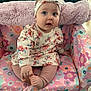 baby, child, infant, sitting, floral_outfit, headband, cushioned_chair, colorful, pattern, foot, hand, indoor, carpet, cute, person, portrait, young_child, clothing, pink, happy