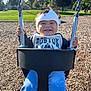 toddler, child, swing, playground, helmet, smile, happy, outdoor, grass, trees, sunshine, clothing, park, daytime, person, seat, metal, holding, fun, woodchips