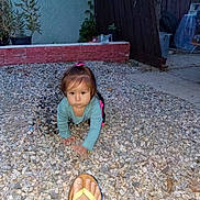 Jazlyn joined the competition — help win amazing prizes! baby, child, crawling, outdoor, gravel, garden, patio, plants, flowerpot, fence, brick_wall, house, curious, face, portrait, long_sleeves, hair_bow, flip_flop, adult_foot, daylight