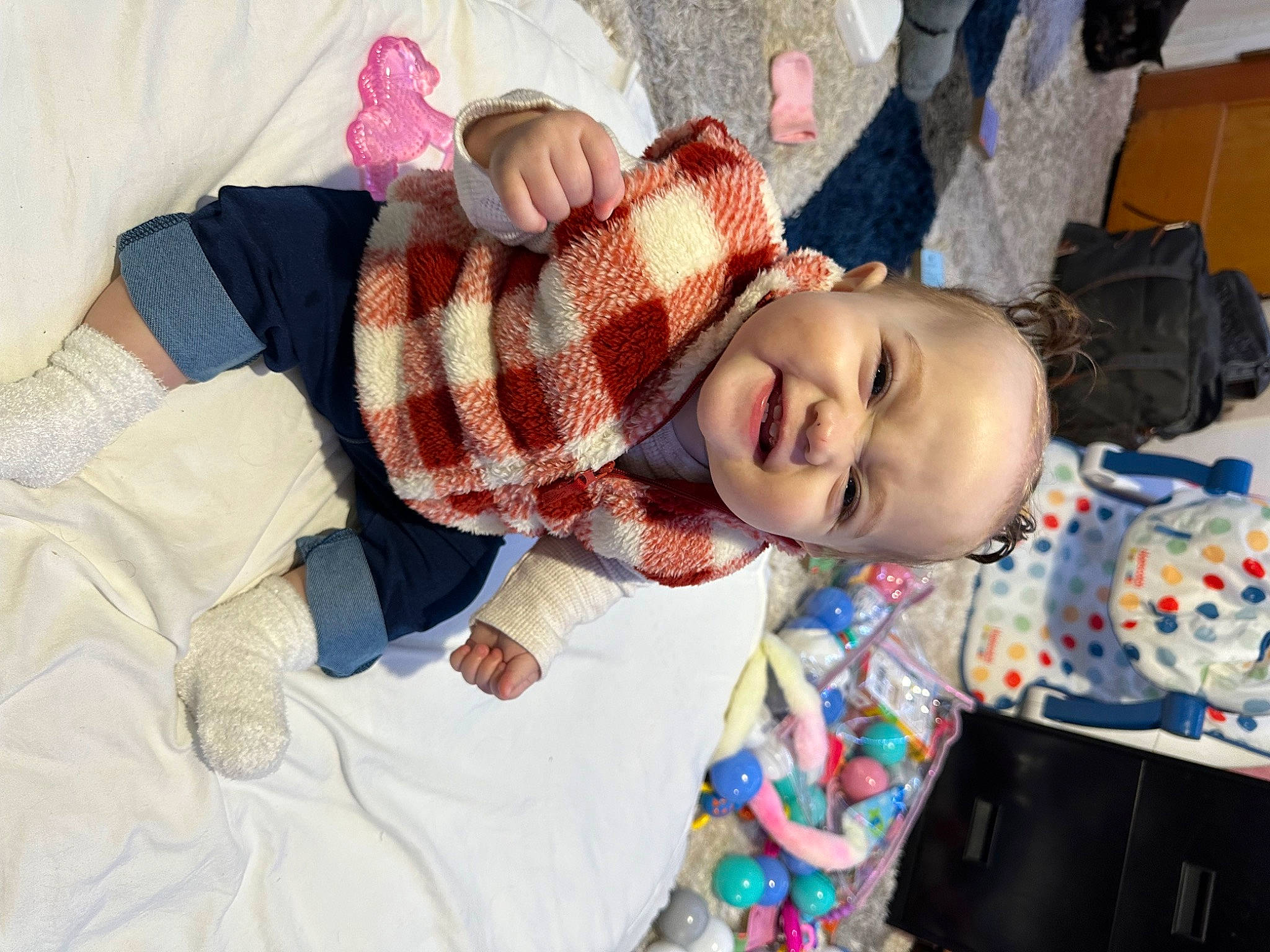 Koda is registered to the contest to win money with this photo: baby, baby_toddler_clothing, backpack, bag, bedding, child, comfort, fun, happy, hat, leisure, linens, luggage_and_bags, pattern, person, plaid, room, smile, tartan, toddler