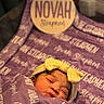 newborn, baby, sleeping, wrapped, blanket, headband, yellow_bow, purple, soft, cute, infant, peaceful, closeup, portrait, child, indoors, cozy, resting, face, person