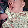 Angelia joined the competition — help win amazing prizes! baby, infant, surprised_expression, floral_outfit, blanket, lying_down, cute, face, head, skin, person, newborn, child, human, indoors, fabric, pattern, colorful, small, young