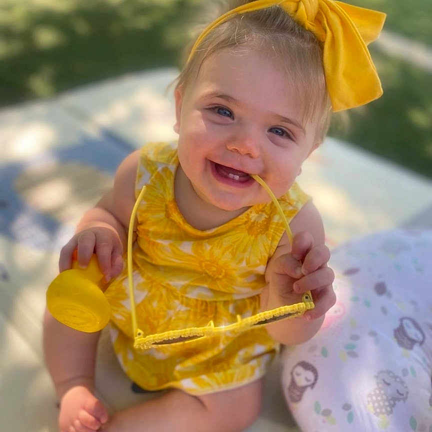 Natalie is registered to the contest to win money with this photo: animal, baby, bodypart, canine, clothing, coat, dog, face, finger, grass, hand, happy, head, person, pet, photography, plant, portrait, smile, text