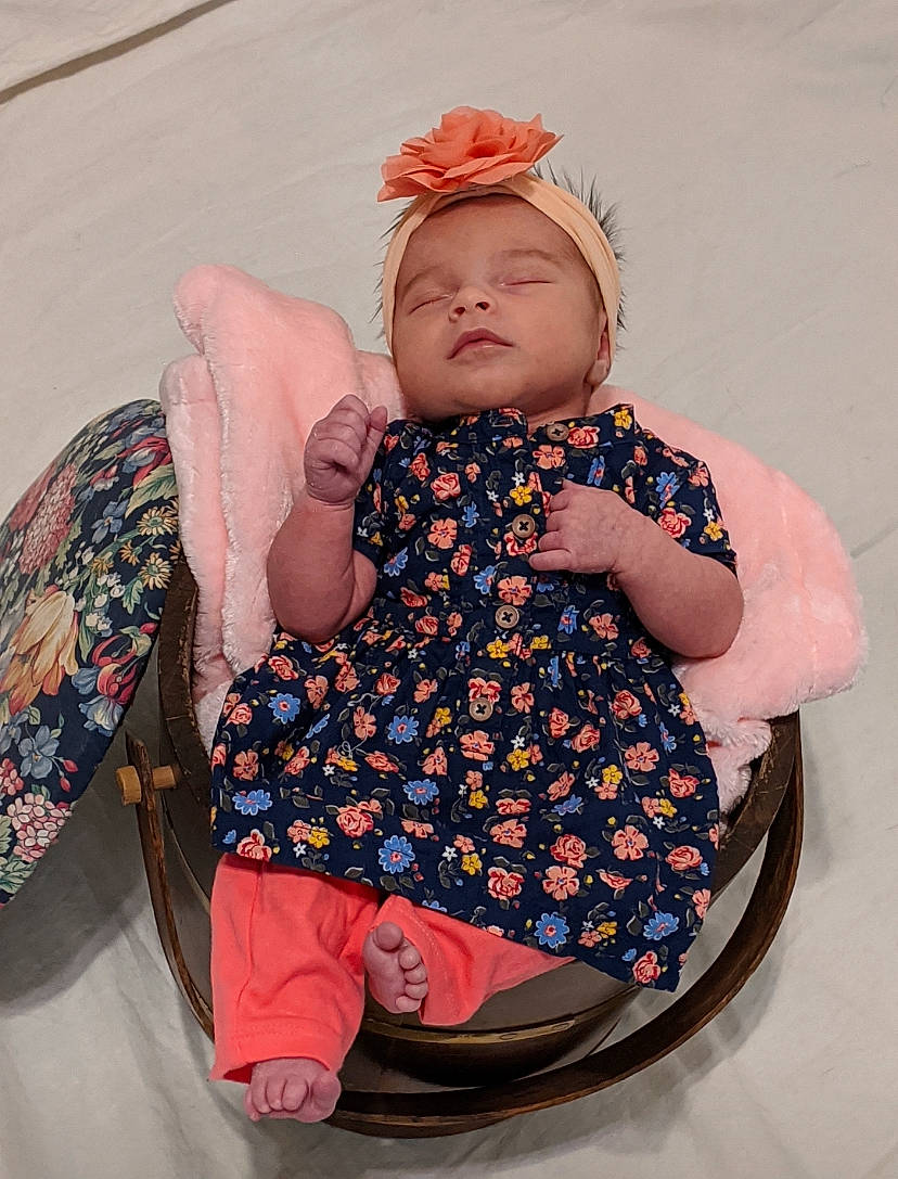 Amira is registered to the contest to win money with this photo: baby, baby_products, baby_toddler_clothing, child, fashion_accessory, hair_accessory, headgear, pattern, person, pink, product, toddler