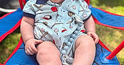 Brooks is registered to the contest to win money with this photo: baby, child, smile, cap, chair, outdoor, grass, clothing, infant, happy, person, legs, feet, seat, sunlight, baseball_theme, blue, red, cute, expression