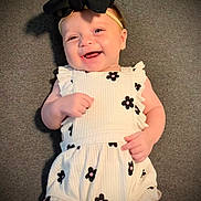 Zoie joined the competition — help win amazing prizes! baby, smiling, headband, bow, dress, flower_print, infant, happy, lying_down, carpet, cute, child, portrait, one_person, indoors, fashion, young_child, skin, head, hand